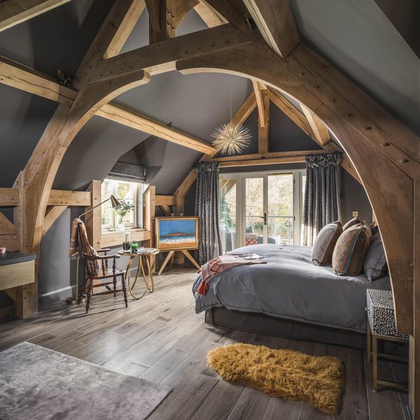 bedroom with oak beams lining the ceiling